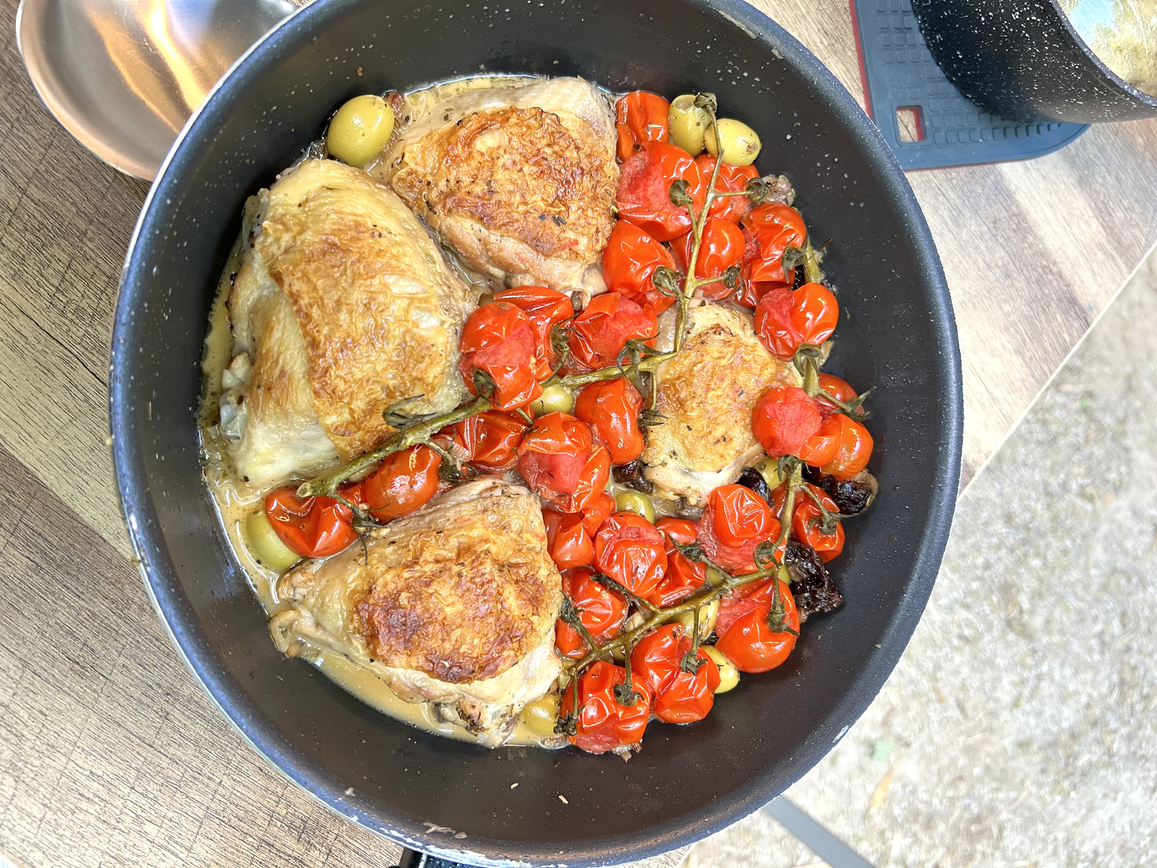 Chicken Provençale with vine cherry tomatoes and olives in a skillet pan